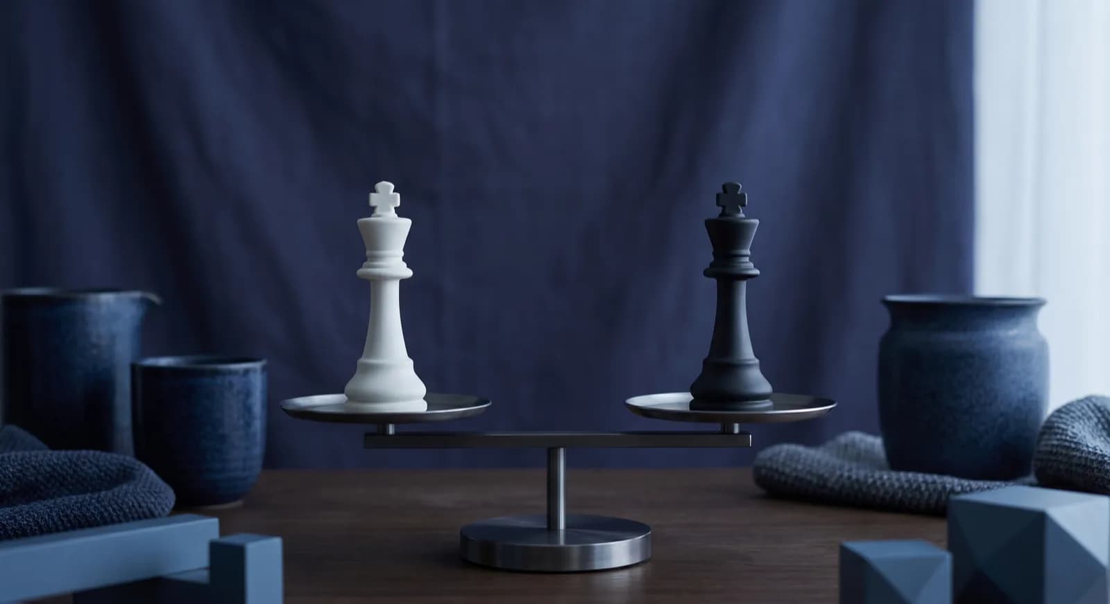 A balance scale weighing a white chess king against a black chess king